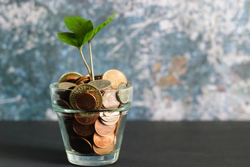 Coins in a glass, Saving money for growth opportunities
